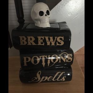 Cookie Jar with skull head on top of a stack of books.